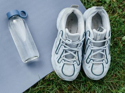 Close up of sports shoes and a water bottle.