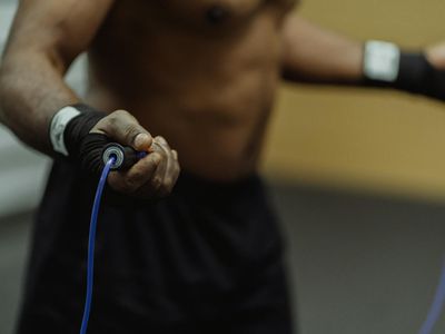 Person hands holding a jump rope in a studio.